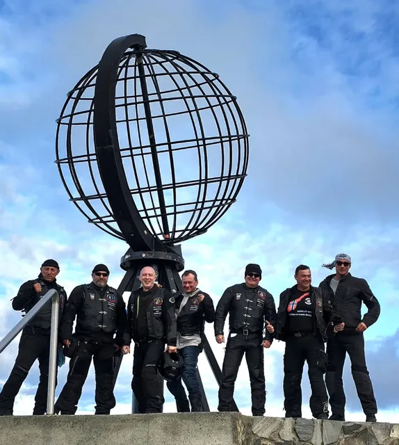 Grupa Right Riders pod pomnikiem globusa na Nordkapp podczas wyprawy w 2025 roku